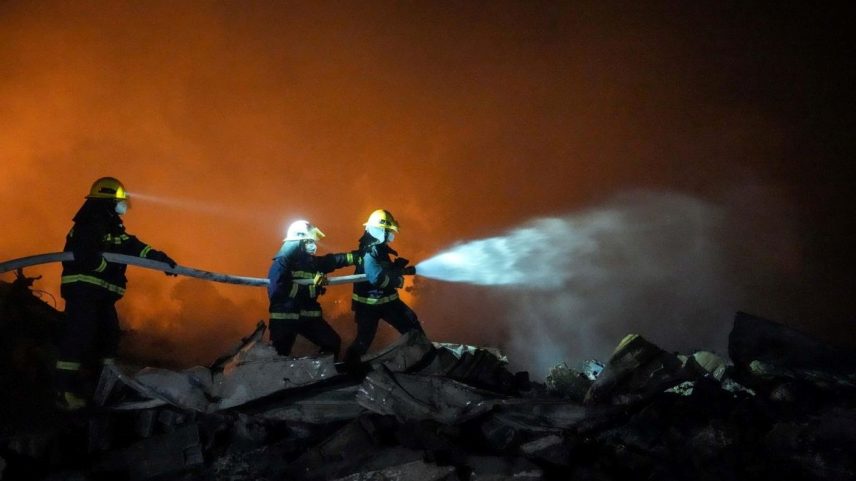 Foto colorida de bombeiros apagando fogo em fábrica de fogos de artifício na China - Metrópoles
