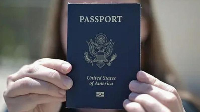 Getty Images A woman holds up her US passport, blocking her face with it.