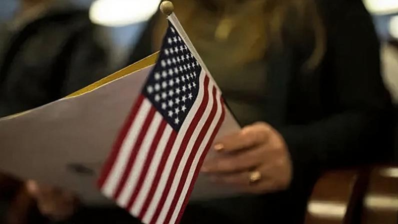 Getty Images A newly sworn in US citizen holds a US flag while listening to a speech from a US government employee at a naturalization ceremony for new US citizens February 16, 2017 in Newark, New Jersey