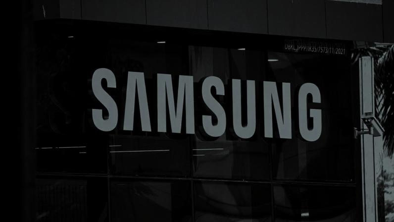 Fachada de prédio com letreiro da Samsung em destaque, em imagem preto e branco.