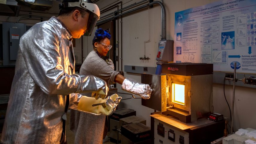 Researchers Dr. Kevin Yu, left, and Dr. Jamesa Stokes prepare to remove a sample of a new material they discovered from a furnace inside a laboratory at NASA’s Glenn Research Center in Cleveland in October 2024. Quenching, or bringing the temperature of the sample down as quickly as possible, helps to ensure no more reactions occur as the sample cools so scientists can focus on studying how it behaves at high temperatures.