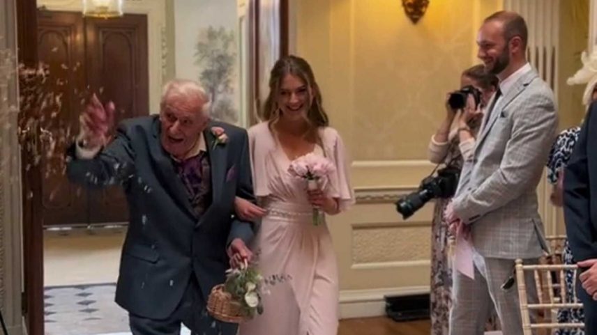 Idoso e madrinha entrando em cerimônia de casamento