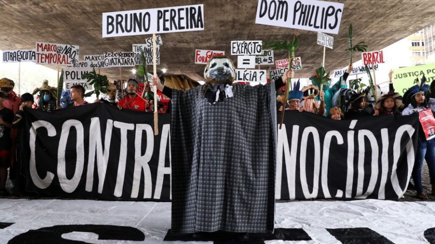 Manifestantes vestidos com fantasias de animais seguram cartazes durante um protesto organizado por indígenas Guarani e ativistas ambientais para exigir justiça pelo assassinato do jornalista britânico Dom Phillips e do ativista indígena Bruno Pereira