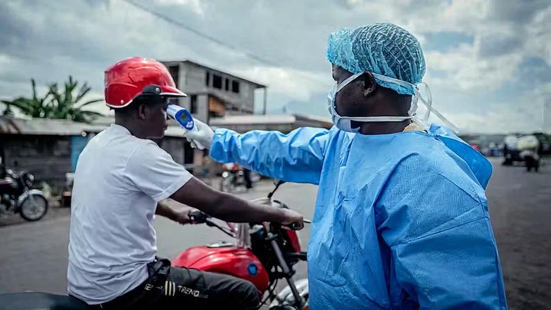 Profissionais de saúde realizam procedimentos de higienização e lavagem das mãos, além de aferição de temperatura, em viajantes no posto de controle de Kanyaruchinya, próximo a Goma, como parte das medidas preventivas contra o vírus Ebolana República Democrática do Congo, em 25 de maio de 2026.