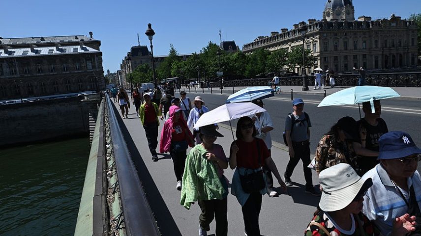 Visitantes usam guarda-chuvas para se proteger do sol durante as altas temperaturas em Paris, França, na terça-feira, 26 de maio de 2026.