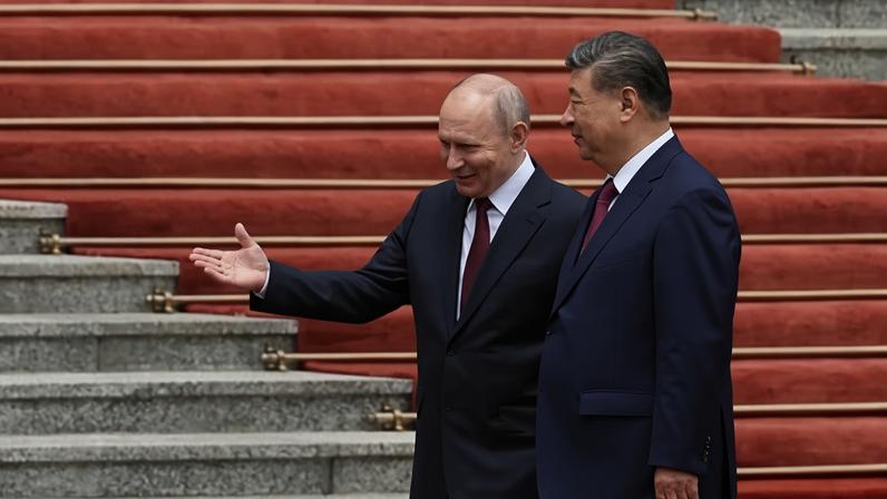 O presidente russo Vladimir Putin caminha com o líder chinês Xi Jinping durante uma cerimônia de boas-vindas no Grande Salão do Povo, em Pequim, em 20 de maio