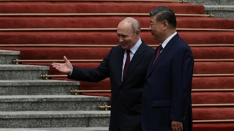 O presidente russo Vladimir Putin caminha com o líder chinês Xi Jinping durante uma cerimônia de boas-vindas no Grande Salão do Povo, em Pequim, em 20 de maio