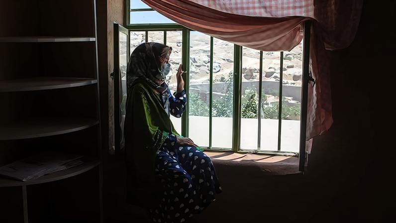 Menina do Afeganistão olha pela janela