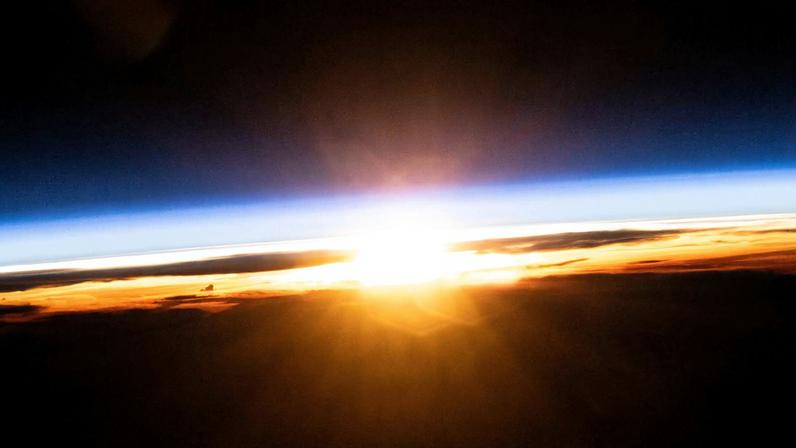 The last rays of an orbital sunset illuminate Earth's atmosphere and the cloud tops in this photograph from the International Space Station as it orbited 258 miles above the Pacific Ocean north of Papua New Guinea.