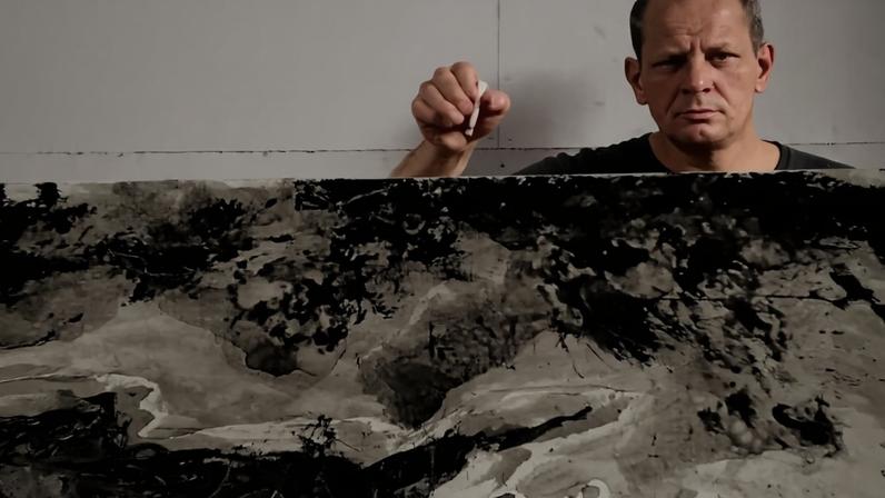 American abstract expressionist painter Jackson Pollock (1912 - 1956) holds a cigarette above and behind one of his paintings in his studio at 'The Springs,' East Hampton, New York, August 23, 1953. (Photo by Tony Vaccaro/Getty Images)