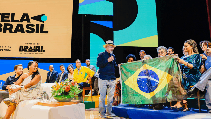 Após defender que a esquerda use verde e amarelo na Copa do Mundo, Lula posa com a bandeira do Brasil em evento no Rio