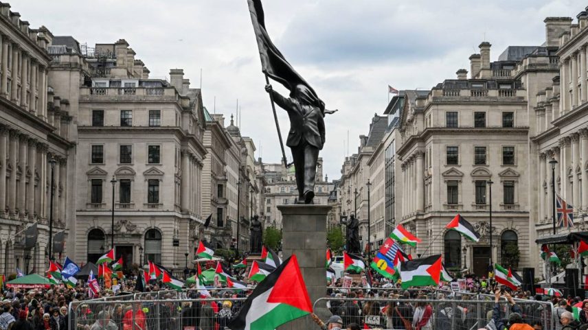 Pessoas seguram bandeiras palestinas ao lado de estátua do britânico Banksy, durante marcha realizada pela Palestine Solidarity Campaign, para marcar o 78º aniversário da Nakba e contra o comício "Unite the Kingdom" organizado pelo ativista anti-imigração britânico Stephen Yaxley-Lennon, em Londres, Grã-Bretanha, 16 de maio de 2026. REUTERS/Chris J Ratcliffe