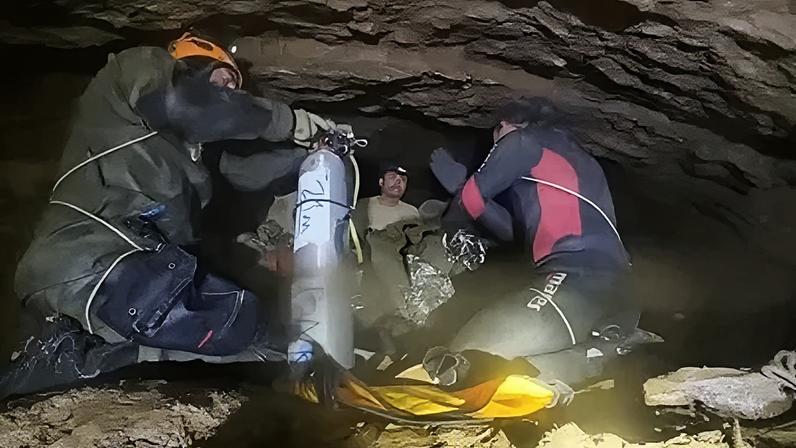Nesta imagem capturada de um vídeo publicado em uma rede social no dia 30 de maio, mergulhadores de uma equipe internacional de resgate mostram aos moradores presos como usar o equipamento de mergulho na província de Xaisomboun, no Laos.