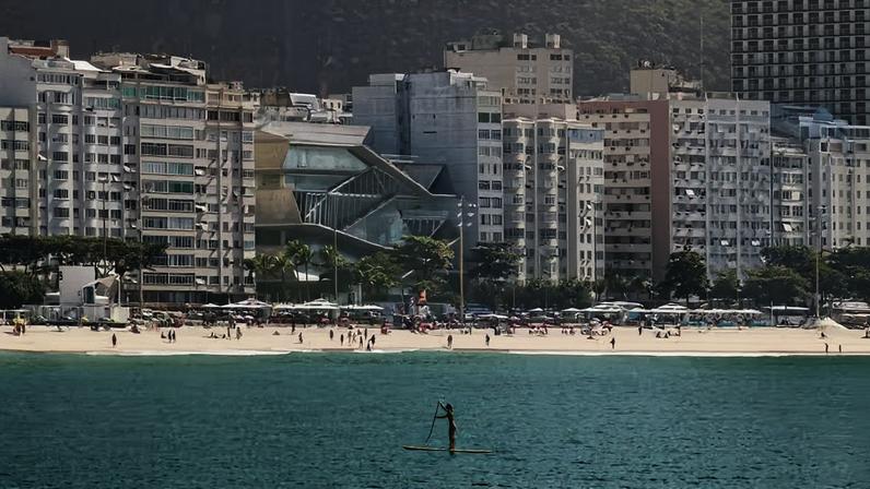 Inserido entre edifícios residenciais da orla, o MIS Copacabana rompe a linearidade da paisagem com uma volumetria em movimento, pensada para ser percebida em percurso – da areia ao topo do edifício
