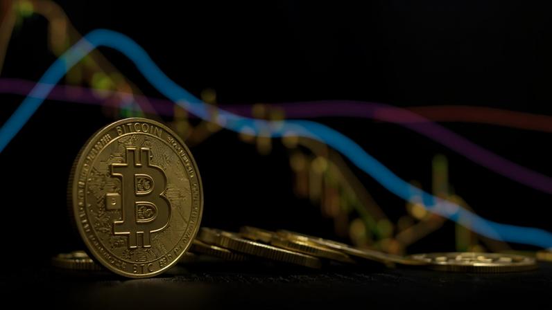 moeda de bitcoin com gráfico de queda ao fundo