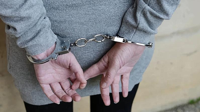 Arrested woman in handcuffs behind her back