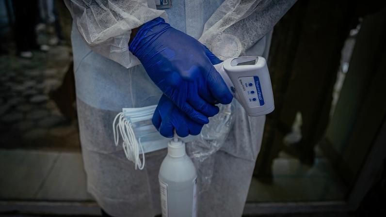 Um profissional de saúde monitora os visitantes que chegam ao Laboratório Rodolphe Mérieux, do Instituto Nacional de Pesquisa Biomédica (INRB), no Congo