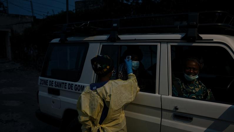 Um visitante tem sua temperatura verificada por um profissional de saúde usando um termômetro infravermelho antes de entrar no Hospital Kyeshero