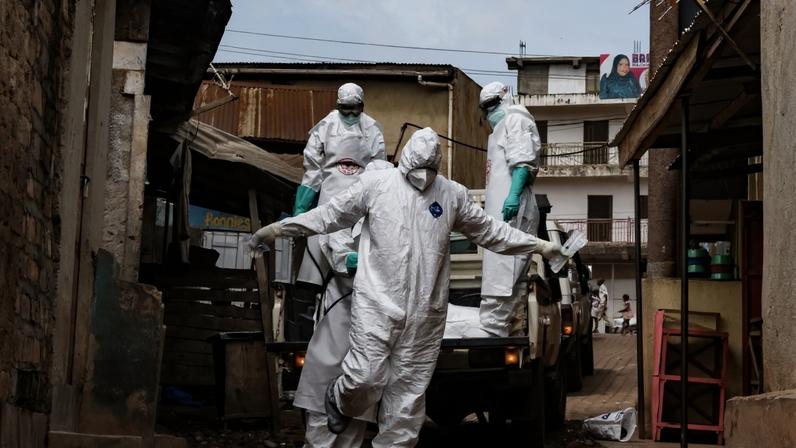 Um funcionário da Cruz Vermelha pulveriza desinfetante durante a remoção do corpo de uma suposta vítima de ebola em Uganda