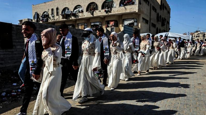 Noivos palestinos se reúnem durante uma celebração de casamento coletivo organizada pela Fundação Turca de Ajuda Humanitária (IHH) na Cidade de Gaza