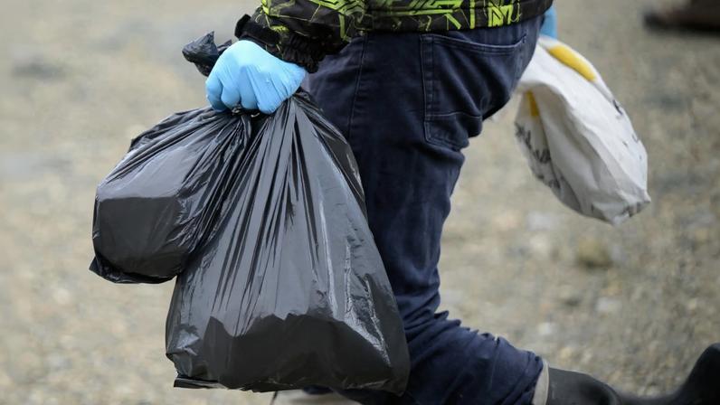 Cientista do Ministério da Saúde carrega ratos capturados com armadilhas perto de Ushuaia. Crédito: JUAN MABROMATA / AFP