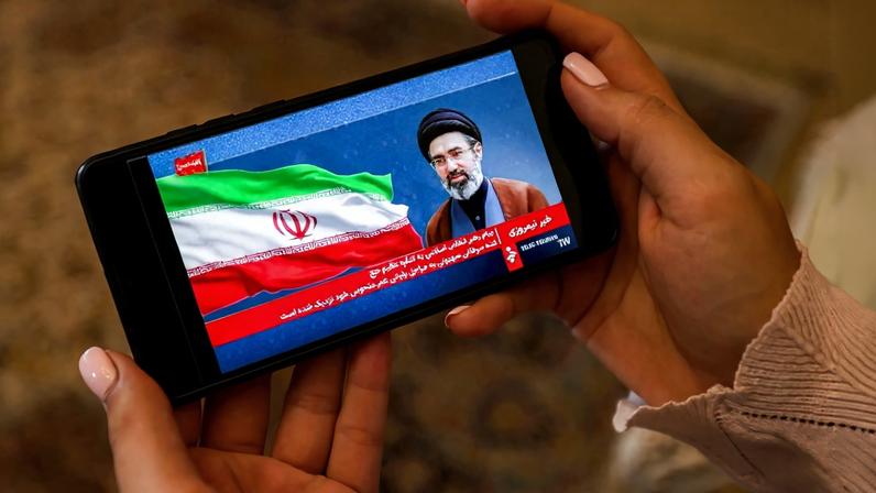Uma mulher assiste a uma transmissão televisiva feita em nome do Líder Supremo do Irã, Mojtaba Khamenei, em Teerã. Crédito: ATTA KENARE / AFP