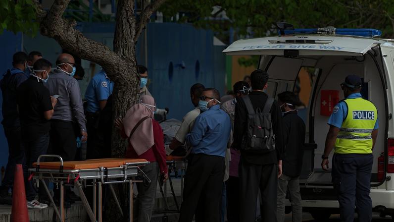 Equipes transferem os corpos de turistas italianos de uma lancha da polícia para uma ambulância em Malé. Crédito: MOHAMED AFRAH / AFP