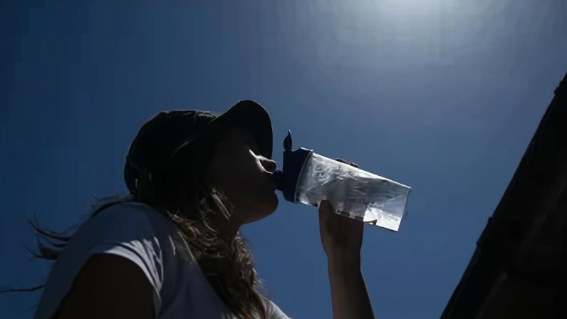 Mulher tenta se refrescar bebendo água durante uma onda de calor em Londres, Reino Unido, em 26 de maio de 2026
