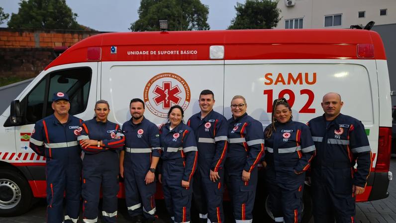 Equipe do SAMU 192 em frente à ambulância, em área urbana