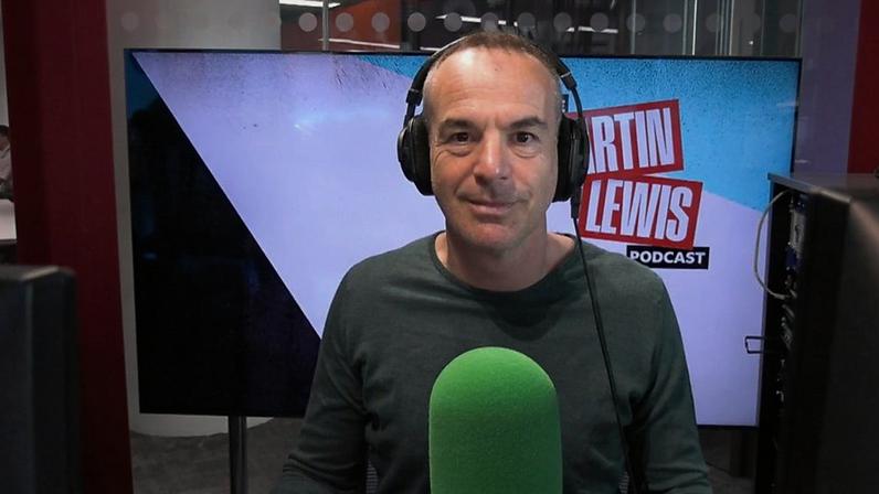 Martin has headphones on his head and is wearing a green long-sleeved top