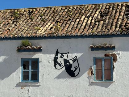 Fachada de casa antiga com máscaras de teatro em Portugal