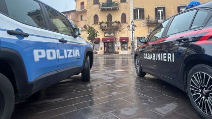 Dois carros pertencentes à polícia italiana e aos Carabinieri estacionados lado a lado em frente a um prédio