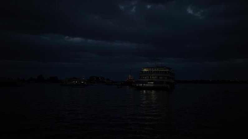 Vista aérea de Tefé AM, com o Lago Tefé e o Rio Solimões; barcos regionais e a faixa urbana ao fundo