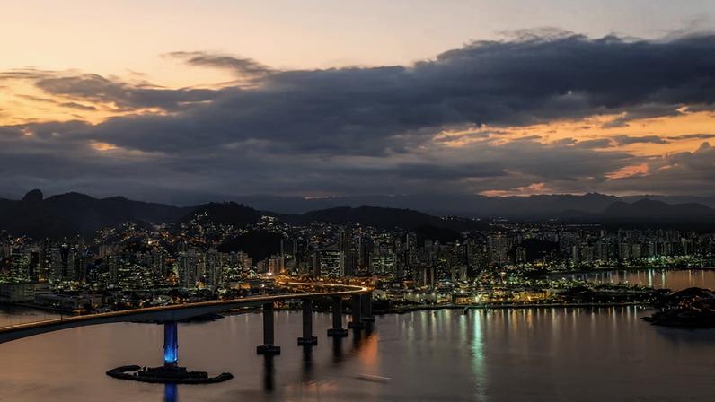 Vista aérea de Vitória ES com a Terceira Ponte ao fundo, ao entardecer