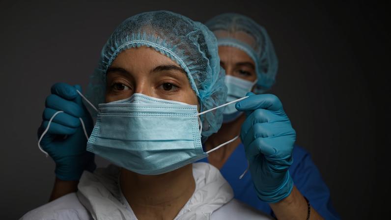 Equipe de profissionais de saúde em hospital público, com jalecos e EPI