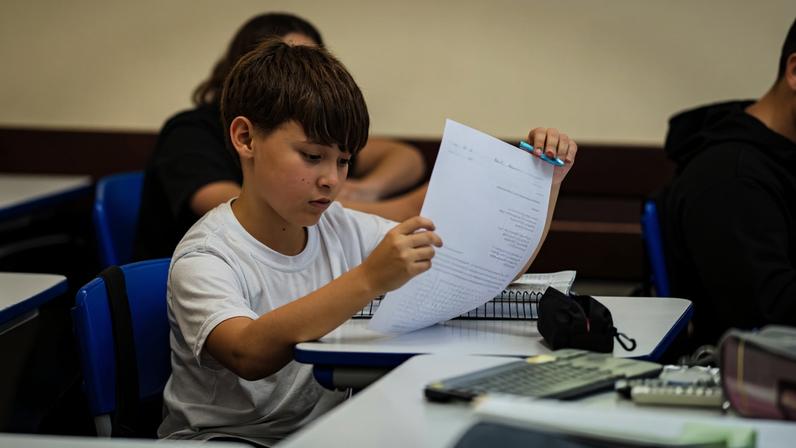 Ambiente acadêmico em sala de aula, com professor e estudantes durante atividade. Créditos: Governo do Estado do Paraná.