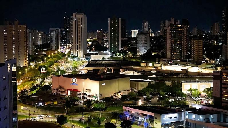 Vista noturna urbana com ruas iluminadas e comércio em Confresa MT. Foto: Blog Plaenge.