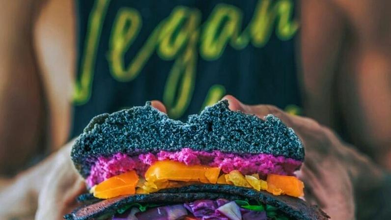 Carnes, ovos e leite mostram inequívoca vantagem alimentar sobre os cereais e frutas; em nome da solidariedade com os animais, ou ainda por crença religiosa, maltrata seu próprio corpo, diz o articulista; na imagem, um homem com a camiseta escrito “vegan” segura um sanduíche sem carne