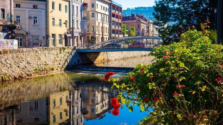 Foto colorida de ponte, lago e edifícios ao redor - Metrópoles