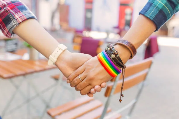 Happy lesbian couple wearing rainbow bracelet