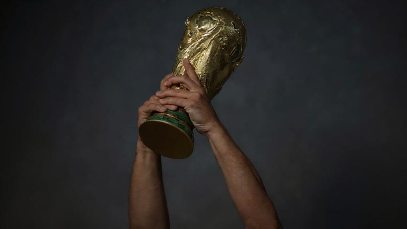 Mãos levantando a Copa do Mundo
