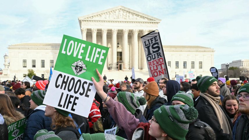 People hold signs in front of the US Supreme Court as they march in the 53rd annual March for Life rally in Washington, DC, on January 23, 2026.