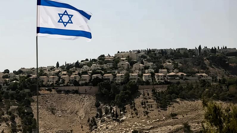 Bandeira israelense na Cisjordânia ocupada por Israel com assentamento Maale Adumim ao fundo