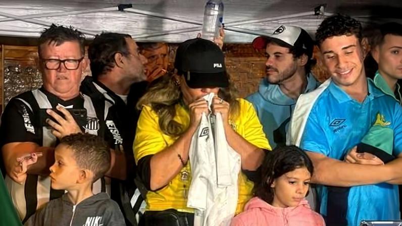 Torcedora reza pela convocação de Neymar em frente ao condomínio do atacante, em Santos