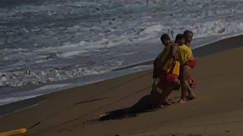 Bombeiros resgatam corpo de homem que morreu na praia de Boiçucanga, em São Sebastião, arrastado pela forte correnteza (GBMar/Divulgação)