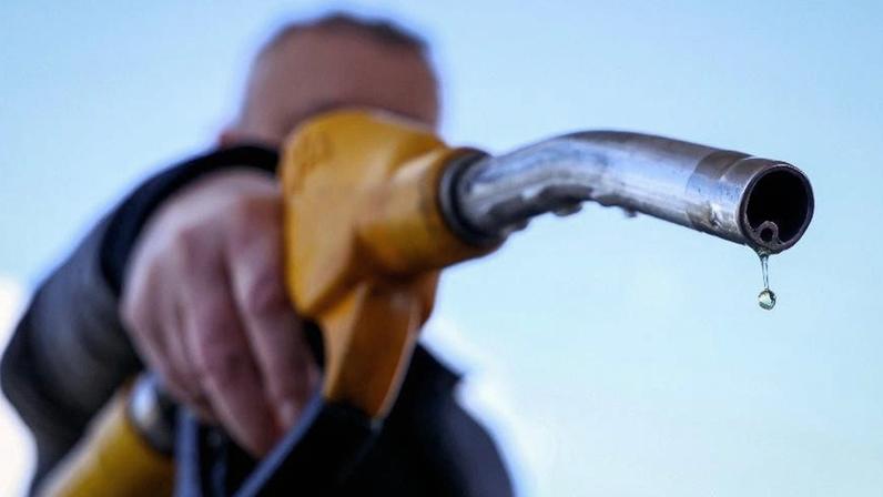 Gota de gasolina cai do bico de uma bomba de combustível em um posto de gasolina