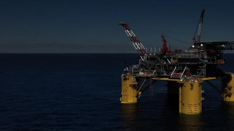 Plataforma de petróleo flutuante no oceano sob céu azul.