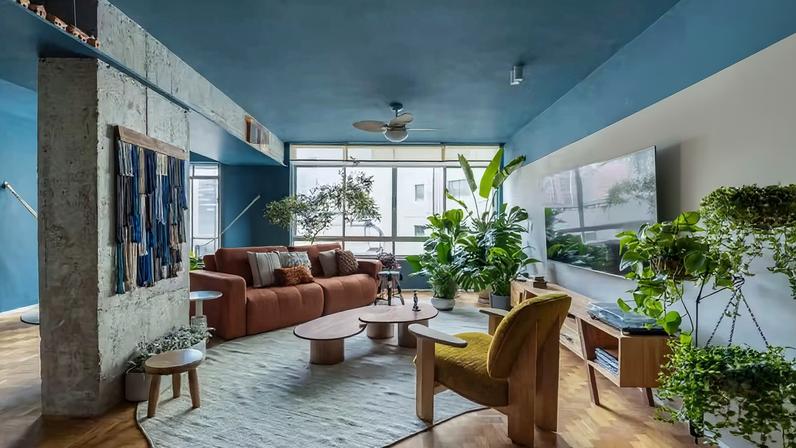 A cor azul, a preferida do morador, impera no ambiente, mesclada com taco de madeira existente do piso e muitas plantas. A poltrona Guaruçá, assinada por Mauricio Arruda para Lider, é um dos destaques. A TV tem como apoio o rack MASP, de Felipe De Lucca