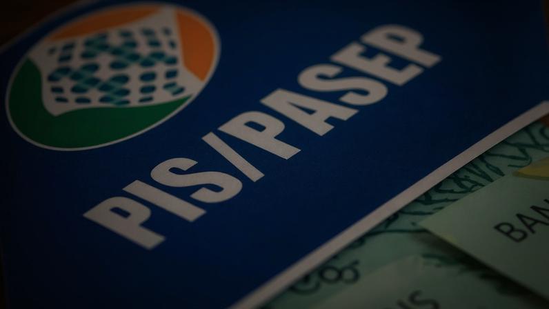 Cartão do PIS/Pasep com dinheiro em volta.