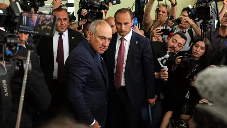 O primeiro-ministro armênio, Nikol Pashinyan, ao centro, olha para os fotógrafos após votar em uma seção eleitoral durante as eleições parlamentares em Ierevan, Armênia, em 7 de junho de 2026.